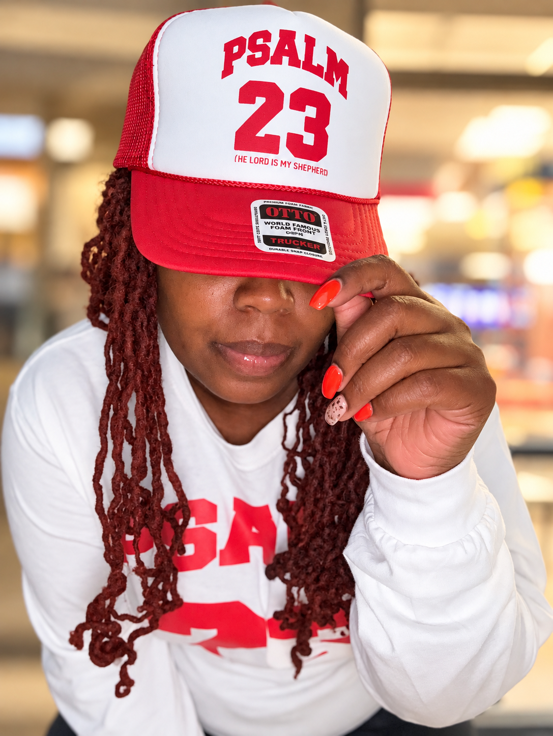 Psalm 23 red and white trucker hat worn in a close-up lifestyle photo